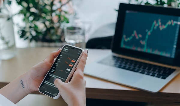 Žena si prezerá vývoj investícií na mobile