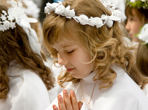 Dievča sa modlí na prvom svätom prijímaní