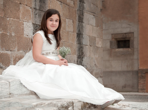 Dievča v slávnostných bielych šatách na prvom svätom prijímaní